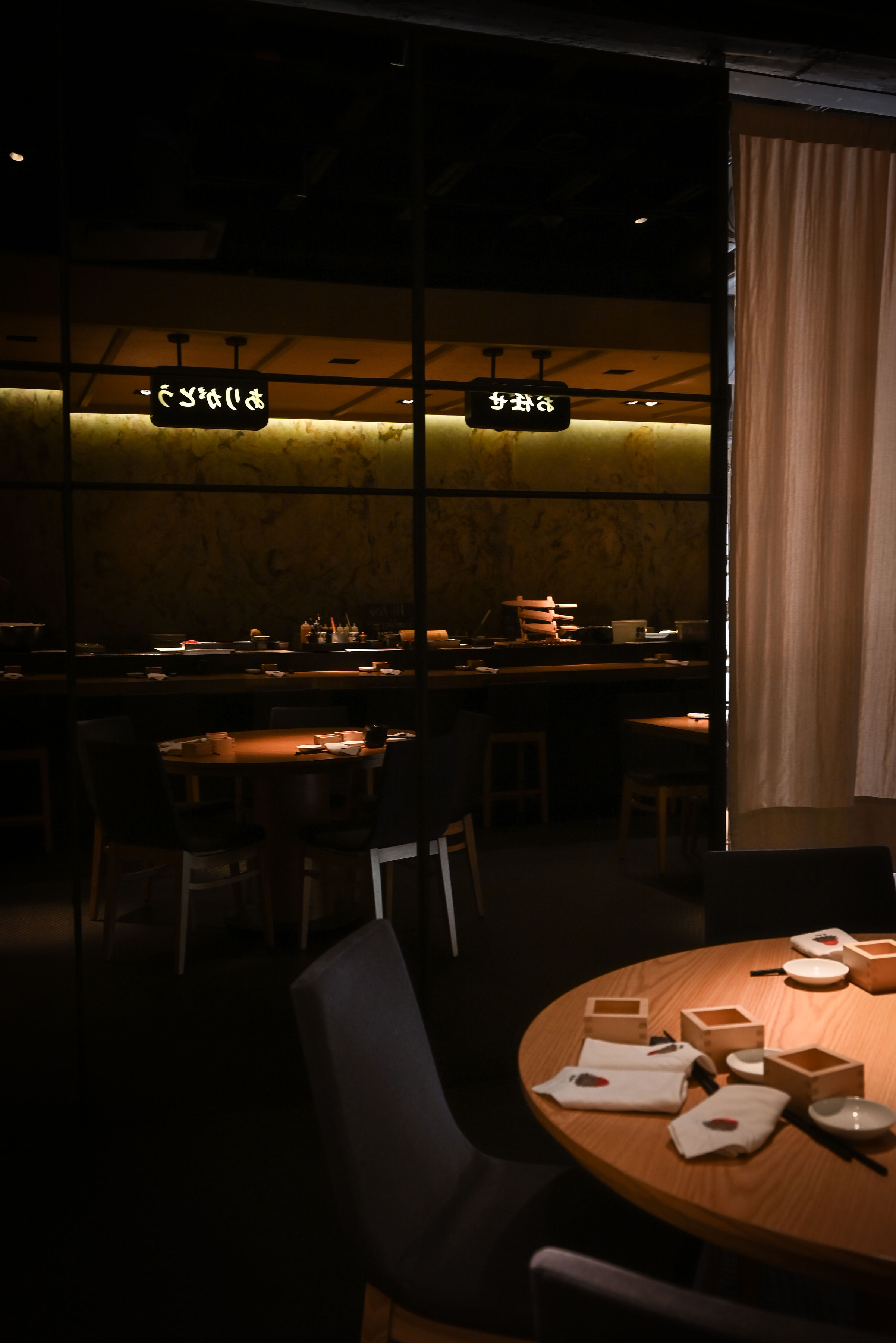 Comedor de Hi-Kov Nigiri House con detalles de madera e iluminación suave