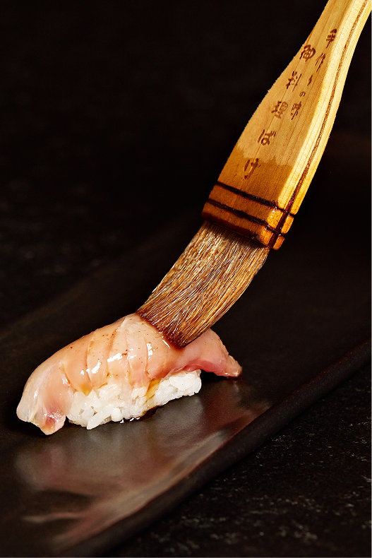 Nigiri barnizado con salsa en la barra de Hi-Kov